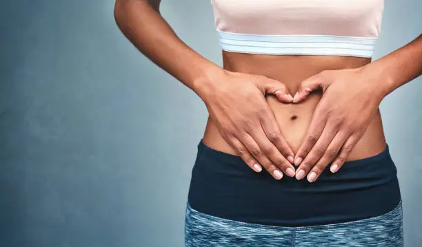 Cropped shot of an unrecognizable woman forming a heart shape in her stomach