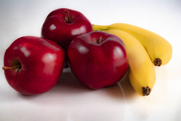 istock red apples with ripe bananas on a white background 1132748183