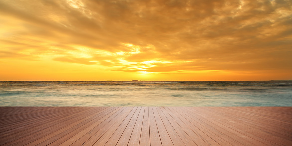 Empty wooden platform with sunset seascape