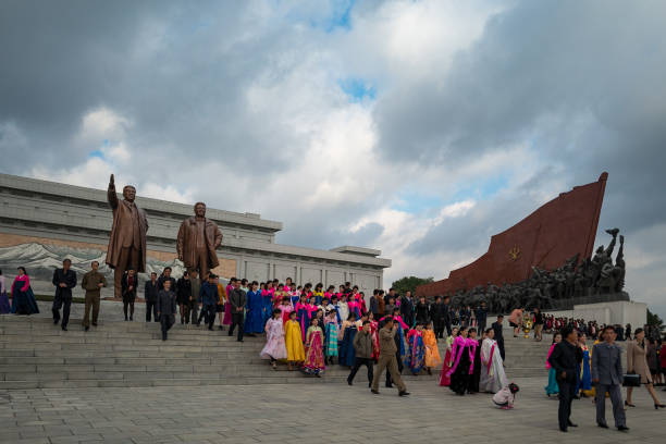 marching solemnly to gigantic bronze statues in pyongyang - tourist photographing armed forces military imagens e fotografias de stock