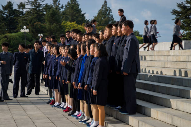 marching solemnly to gigantic bronze statues in pyongyang - tourist photographing armed forces military imagens e fotografias de stock