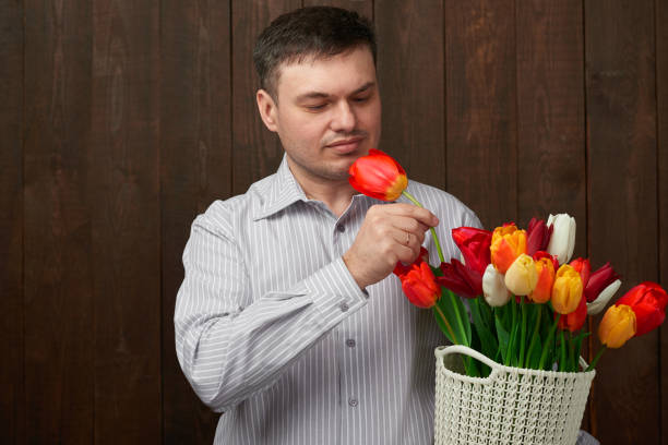istock Man holds a basket with flowers 1132749732