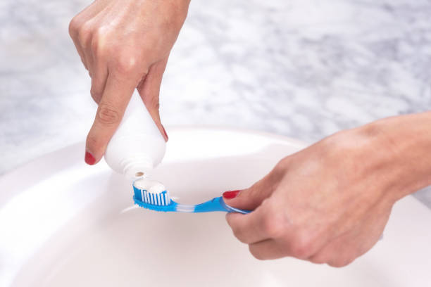istock Woman holding a tooth brush putting toothpaste on it. 1132751936