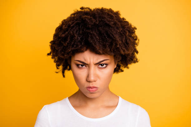 close-up portrait de son elle belle attirante sombre couvert sombre blonde aux cheveux ondulés isolé sur fond lumineux vif brillant jaune - disgust women african ethnicity human face photos et images de collection