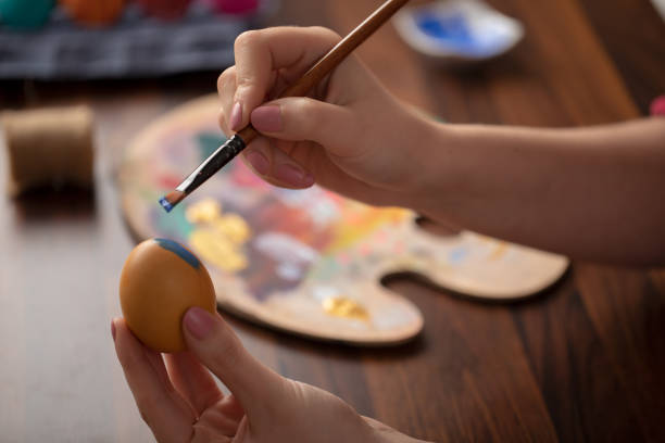 istock DIY young woman paints colorfull easter eggs 1132758689