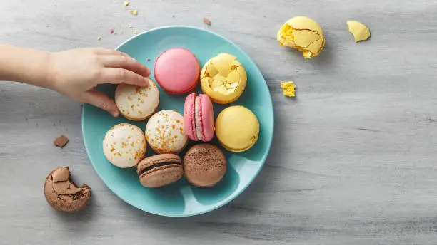 Photo of Colorful macaroons on a plate on a wooden table