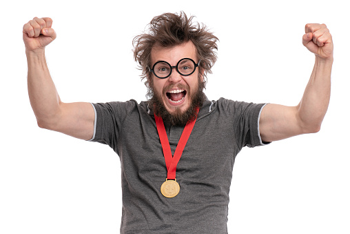 Happy winner. Crazy bearded Man with funny Haircut in eye Glasses celebrating his success. Cheerful Guy with gold Medal, screaming and keeping mouth open, isolated on white background.