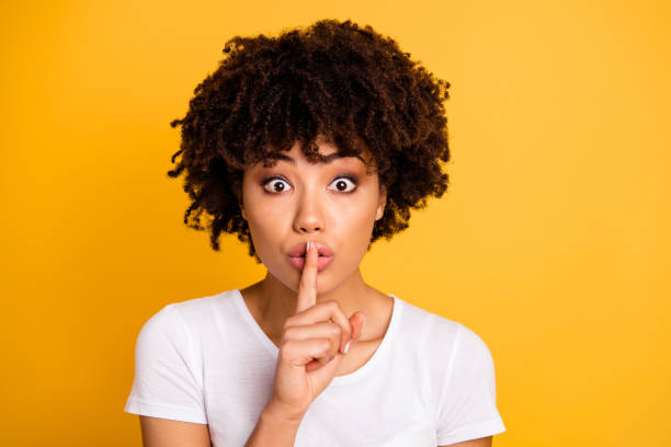 close-up portrait of her she nice cute lovely attractive charming cheerful wavy-haired lady showing shh symbol isolated on bright vivid shine yellow background - finger on lips whispering secrecy silence imagens e fotografias de stock