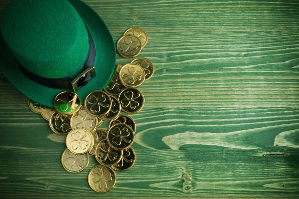 happy st patricks day leprechaun hat with gold coins on vintage green wood background - chocolate coins imagens e fotografias de stock