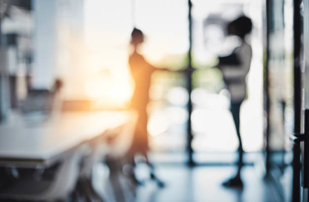 It's been a busy day of doing deals Defocused shot of two businesswomen shaking hands in an office defocused woman stock pictures, royalty-free photos & images