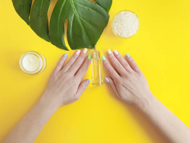 istock female hands manicure, cosmetic cream, monstera leaf, on a yellow background 1132765355
