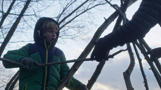 istock Father building teepee with sons. Riverside in the city 1132766998