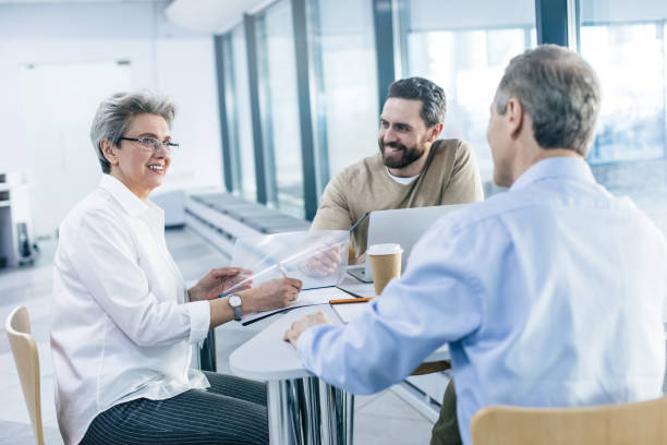 istock Gray-haired woman talking to man while sitting at table 1132768185