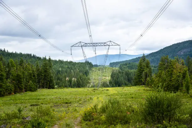 Photo of High Voltage Power Lines in the Mountains and Cloudy Sky