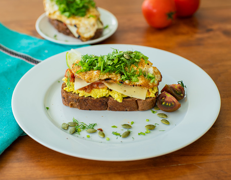 Breakfast sandwich with avocado and eggs on top