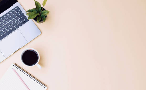 istock office workspace yellow desk table with laptop, coffee, mobile, notebook, plant. flat lay 1132769884