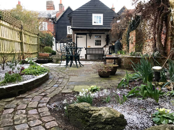 An English cottage garden Amersham, UK - 2018: A cottage garden in winter. The picture is taken in February when first flowers started to show through the snow amersham stock pictures, royalty-free photos & images
