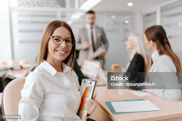 Portrait Of Beautiful Caucasian Brunette Sitting At Meeting In Board Room And Holding Clipboard Excellence Is Not A Destination Its A Journey That Never Ends Stock Photo - Download Image Now
