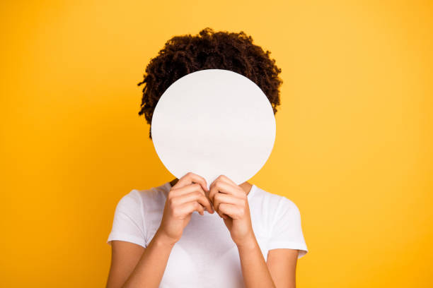 close up photo beautiful amazing she her dark skin lady hiding face round circle banner placard do not want be recognized wear casual white t-shirt isolated yellow bright vibrant vivid background - hairstyle human hair women human face imagens e fotografias de stock