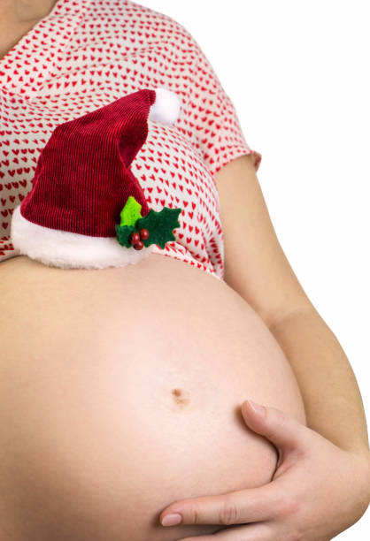 istock Pregnant woman's cute belly with Santas hat on white background 1132778721