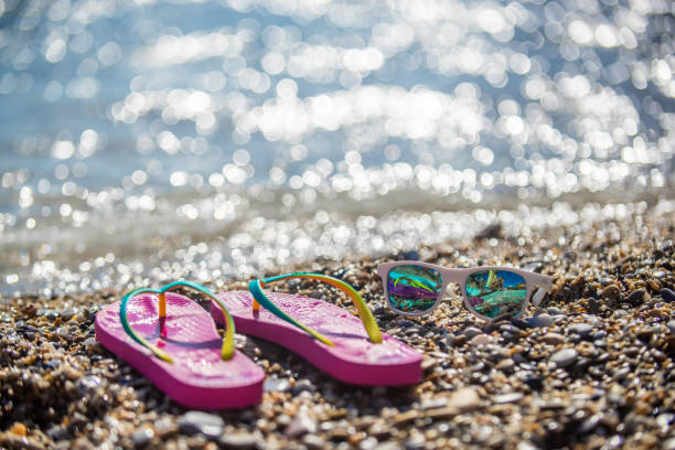 istock Flip-flops with sunglasses on beach 1132778906