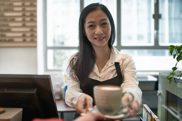 istock Female barista smiling while serving coffee 1132780798