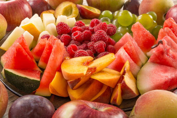 A mixture of their fruit, close-up. A mixture of their fruit. Peach, grapes, apple, watermelon, melon, raspberry, plum. Juicy and ripe pieces of fruit close-up. fruit salad stock pictures, royalty-free photos & images