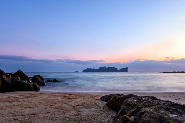istock (long exposure) View of a beautiful tropical beach during the sunset with rocks and smooth clear water, Ko Phi Phi Le (Maya Bay) in the distance. Thailand. 1132785645