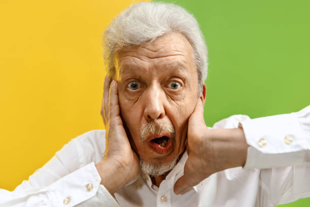 istock The senior man looking suprised isolated on color studio background 1132785813
