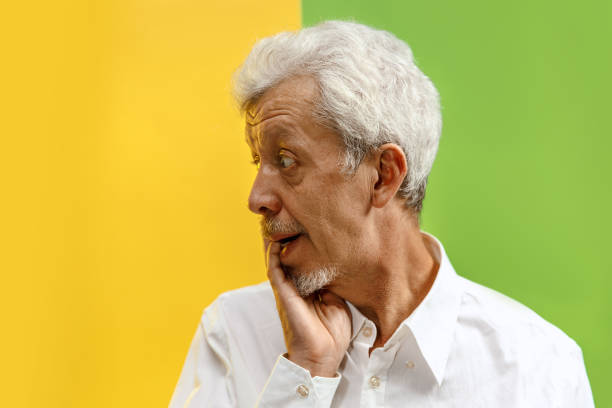 istock The senior man looking suprised isolated on color studio background 1132785817