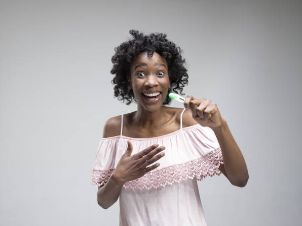 istock Smiling young woman looking on pregnancy test 1132787265