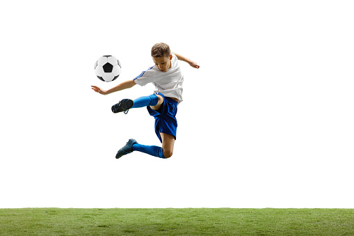 Young boy with soccer ball running and jumping isolated on white. football soccer player in motion on studio background.