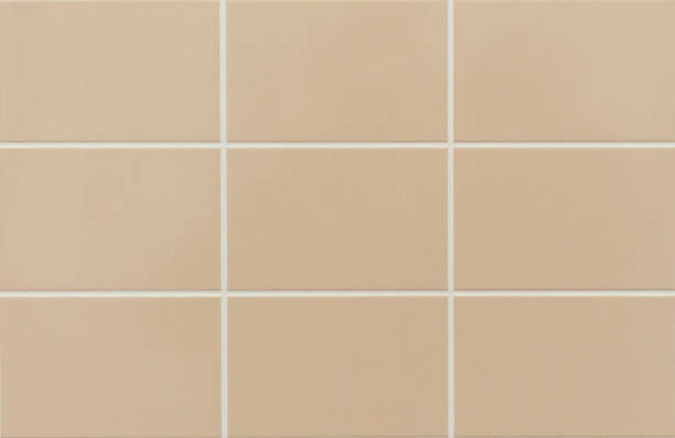 istock Beige ceramic tile on the wall in the bathroom. Background from beige tiles. 1132788557