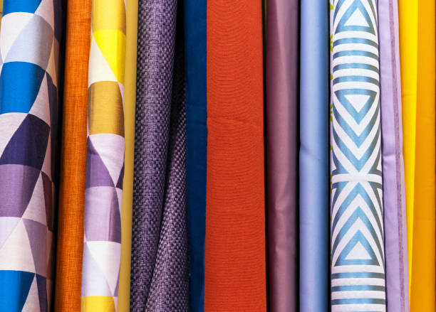 istock Multicolored curtain designs in a retail store window. Samples of the texture of multi-colored fabrics. 1132788708