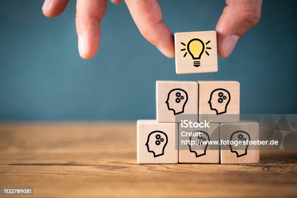 Many People Together Having An Idea Symbolized By Icons On Cubes Stock Photo - Download Image Now