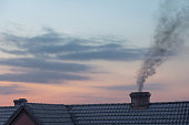 Chimney with smoke and sunset sky