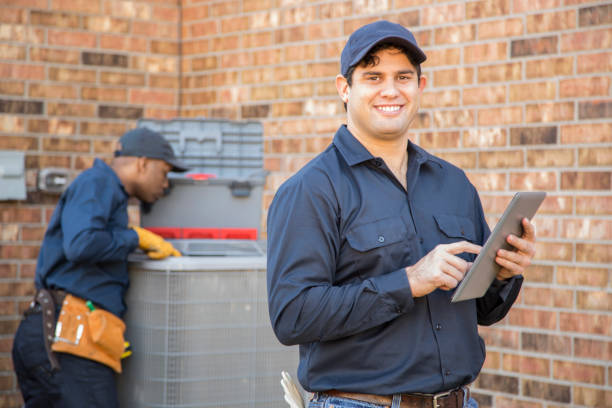 istock Multi-ethnic team of blue collar air conditioner repairmen at work. 1132791376