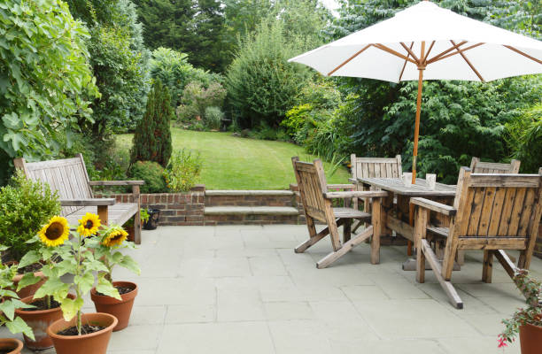 Patio with garden furniture and parasol London garden in summer with patio, wooden garden furniture and a parasol or sun umbrella formal garden stock pictures, royalty-free photos & images