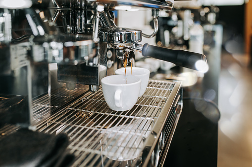 Human hands making fresh espresso coffee drink