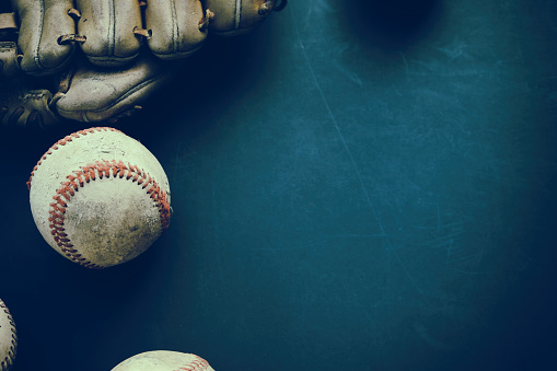 Old baseball with glove flat lay on grunge background with copy space for sports team season.
