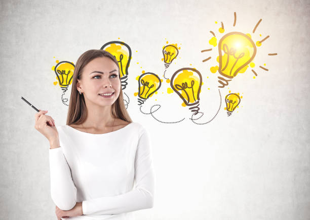 istock Smiling woman with pen, many bulbs 1132797504