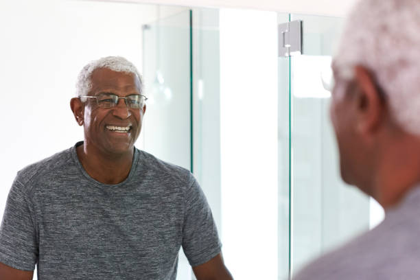 istock Smiling Senior Man Looking At Reflection In Bathroom Mirror Wearing Pajamas 1132797605