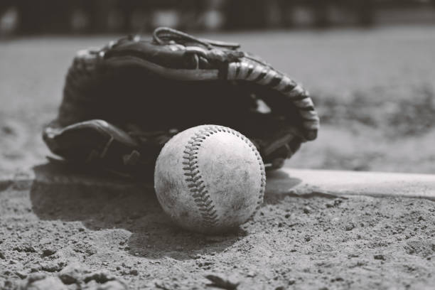 istock Black and white baseball with glove on field. 1132798119