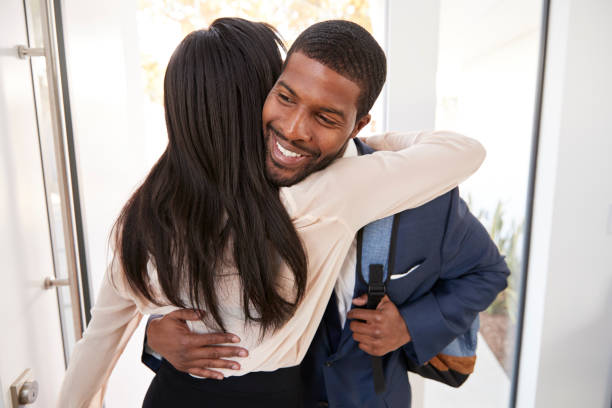 istock Woman Greeting And Hugging Businessman Husband As He Returns Home From Work 1132801945