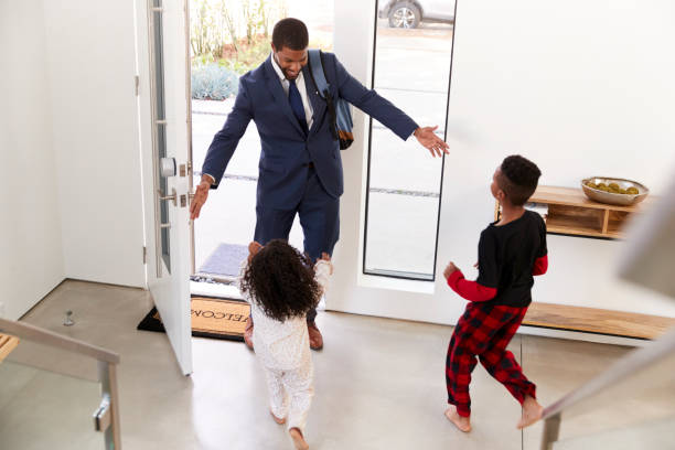 istock Children Greeting And Hugging Working Businessman Father As He Returns Home From Work 1132802095