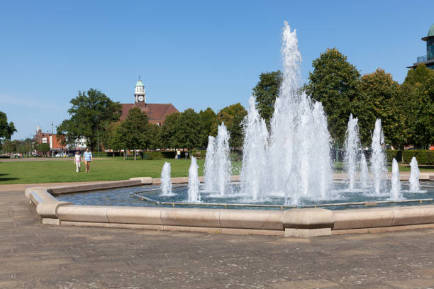 Broadway Gardens in Letchworth. Couple walking towards the fountain in Broadway Gardens, Letchworth, on a sunny day. letchworth garden city stock pictures, royalty-free photos & images