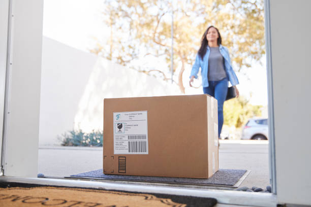 Woman Coming Back To Home Delivery In Cardboard Box Outside Front Door Woman Coming Back To Home Delivery In Cardboard Box Outside Front Door home delivery photos stock pictures, royalty-free photos & images