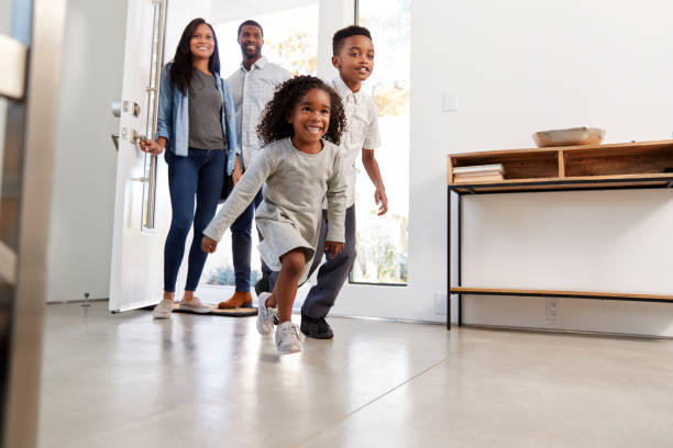 istock Parents And Children Returning Home Opening Front Door And Running Inside 1132805354