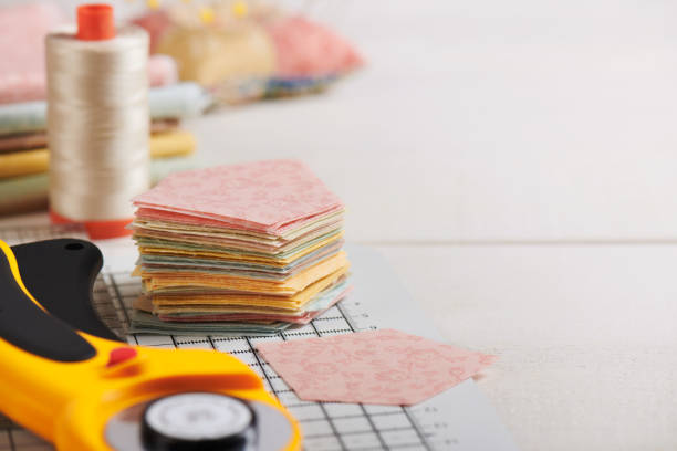 istock Stack of pentagon pieces of fabrics on white craft mat, sewing accessories 1132805554