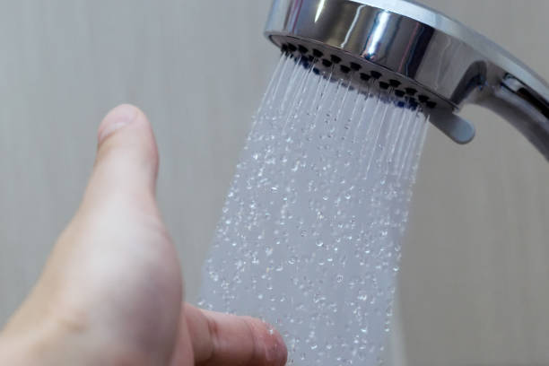 istock hand in the shower test water temperature 1132812135